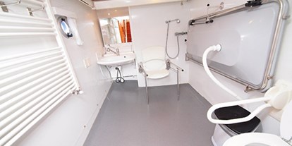 Rollstuhlgerechte Unterkunft - Das Bad mit verstellbarem Waschbecken, Dusche, Toilette (beide mit Haltengriffen) und Klappliege. - Behindertengerechtes Motorschiff ARON zum selber fahren