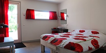Rollstuhlgerechte Unterkunft - Das rote Schlafzimmer hat ein bequemes Doppelbett, das auch als zwei schöne Einzelbetten genutzt werden kann. - ievers yn Fryslân