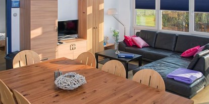 Rollstuhlgerechte Unterkunft - Esstisch und gemütliche Couch des Ferienhauses - Modestia Groepsverblijf Texel