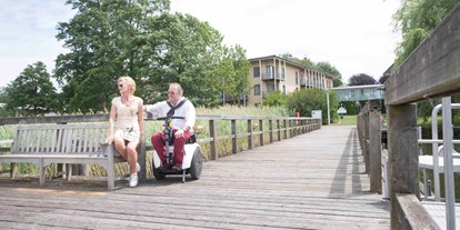 Rollstuhlgerechte Unterkunft - mit dem Rollstuhl befahrbarer Holzsteg - Seehotel Rheinsberg - komplett barrierefreies Hotel am See