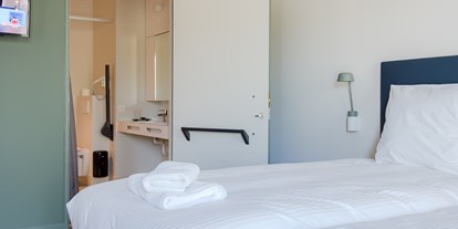 Rollstuhlgerechte Unterkunft - Badezimmer mit unterfahrbarem Waschbecken und Haltegriffen - HOTEL DOMEIN POLDERWIND - Urlaub ohne Einschränkungen
