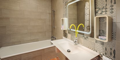 Rollstuhlgerechte Unterkunft - Spanien - Das Badezimmer vom Schlafzimmer Nr 1 mit Badewanne, beleuchteten Spiegel und gelb-grünen biegsamen Wasserhahn. - Poolvilla mit phantastischem Ausblick - mit Pool Lifter