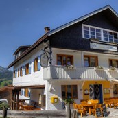 Rollstuhl-Urlaub - Hauptansicht Berggasthof Sonne mit Biergarten und im Hintergrund der Grünten der "Wächter des Allgäu" - Pflegehotel Allgäu