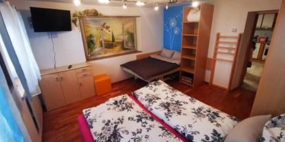 Rollstuhlgerechte Unterkunft - Pflegebett - Flintsbach - Schlafzimmer mit normalem Doppelbett.
Das zweite Bett beim Bild ist eine elektrische Therapieliege mit 120x180 cm. - Ferienwohnung Kaiserblick Kössen