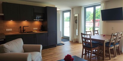 Rollstuhlgerechte Unterkunft - Bayern - offene Küche und Wohnzimmer mit direktem ebenerdigen Zugang auf die Terrasse - Erdhausapartment OST