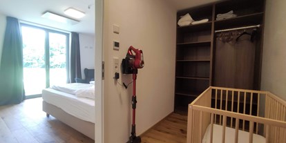 Rollstuhlgerechte Unterkunft - Unterkunftsart: Ferienwohnung - Bayern - begehbares Schrankzimmer bzw Babyzimmer mit Babybettchen (kann auch ins Elternschlafzimmer gestellt werden) und Kinderhochstuhl - Erdhausapartment OST