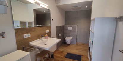 Rollstuhlgerechte Unterkunft - Schwimmbad - Badezimmer mit unterfahrbarem Waschtisch - Erdhausapartment OST