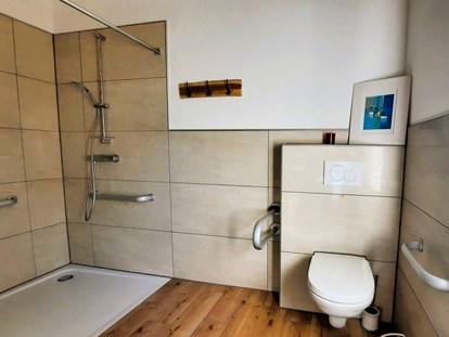 Rollstuhlgerechte Unterkunft - Bayern - Haltestangen beiderseits der Toilette und beiderseits der Dusche. Duschrollstuhl und Duschhocker vorhanden. - Ferienhaus Wollinger
