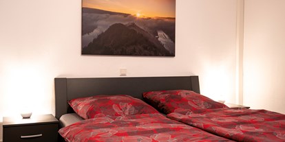 Rollstuhlgerechte Unterkunft - Unterkunftsart: Ferienwohnung - Hunsrück - Schlafzimmer mit hohem Bett und ausreichen Platz neben dem Bett. - Haus Hanghuhn