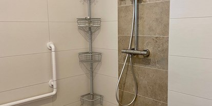 Rollstuhlgerechte Unterkunft - Dusche mit Duschstuhl - Baecker Ferienvermietung und Immobilien