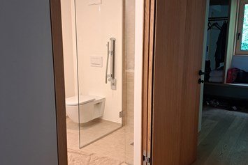 Rollstuhl-Urlaub: Tür ins Badezimmer kann nach aussen bis Anschlag an die Wand geöffnet werden - freiraum Apartments