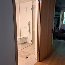 Rollstuhl-Urlaub: Tür ins Badezimmer kann nach aussen bis Anschlag an die Wand geöffnet werden - freiraum Apartments