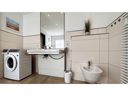 Rollstuhlgerechte Unterkunft - Unterkunftsart: Ferienhaus - Elektrisch höhenverestellbares Waschbecken in "Normalhöhe", Waschmaschine/ Trockner und Bidet - Landhaus Wilkens - Bungalow Nordlicht