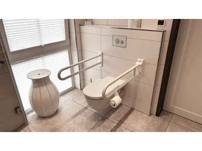 Rollstuhlgerechte Unterkunft - Unterkunftsart: Ferienhaus - Toilette mit Haltegriffen (rechter, vorderer Griff hochklappbar) - Landhaus Wilkens - Bungalow Nordlicht