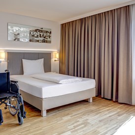 Rollstuhl-Urlaub: Genießen Sie 100%ige Barrierefreiheit auf 23 m² für einen sorgenfreien Aufenthalt. 
(10 barrierefreie Zimmer) 
- Queen-size Bett (160 x 200cm)  
- Das Bett (inklusive Auflage) ist 60 cm hoch aber kann auf Wunsch auf 50 cm verstellt werden.
- Das Bett ist von beiden Seiten komfortabel mit dem Rollstuhl erreichbar (ca. 130 cm Platz zwischen Bett und Wand) - Hotel Zeitgeist Vienna