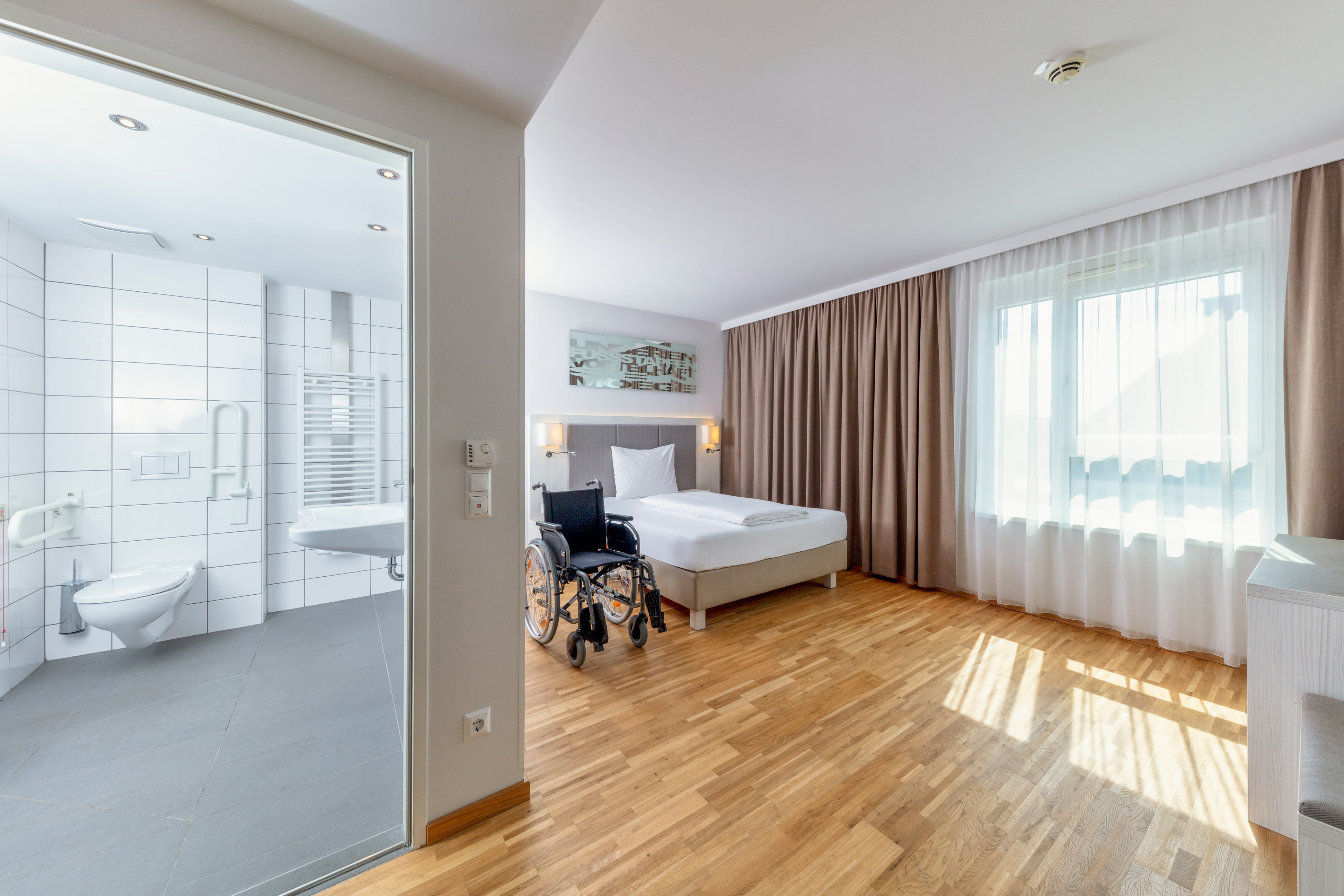 Rollstuhl-Urlaub: Zimmeransicht mit Badezimmer
- unsere Zimmer als auch Badezimmertüren sind 100 cm breit und daher gut mit dem Rollstuhl befahrbar. - Hotel Zeitgeist Vienna