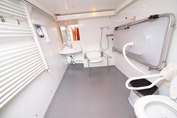 Rollstuhl-Urlaub: Das Bad mit verstellbarem Waschbecken, Dusche, Toilette (beide mit Haltengriffen) und Klappliege. - Behindertengerechtes Motorschiff ARON zum selber fahren