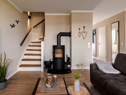 Rollstuhlgerechte Unterkunft - Unterkunftsart: Ferienhaus - geräumiges Wohnzimmer mit Küche, Essbereich, Kamin und Zugang zur Terrasse im Erdgeschoss - Haus Fichte