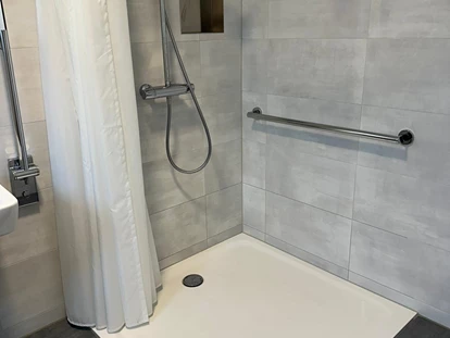 Rollstuhlgerechte Unterkunft - Unterkunftsart: Ferienhaus - befahrbare, ebenerdige Dusche (120x120cm) mit Duschstange - Haus Fichte
