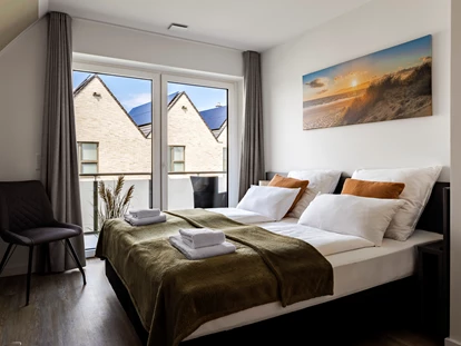 Rollstuhlgerechte Unterkunft - Unterkunftsart: Ferienhaus - Schlafzimmer 2 im Obergeschoss mit 180x200cm Bett, Kleiderschrank, Kommode, Smart-TV, Zugang zum Balkon - Haus Fichte