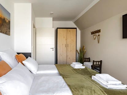 Rollstuhlgerechte Unterkunft - Unterkunftsart: Ferienhaus - Schlafzimmer 2 im Obergeschoss mit 180x200cm Bett, Kleiderschrank, Kommode, Smart-TV, Zugang zum Balkon - Haus Fichte