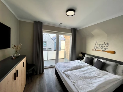 Rollstuhlgerechte Unterkunft - Unterkunftsart: Ferienhaus - Schlafzimmer 2 im Obergeschoss mit 180x200cm Bett und Zugang zum Balkon. Außerdem Kleiderschrank, Kommode und Smart-TV - Korn-Koje
