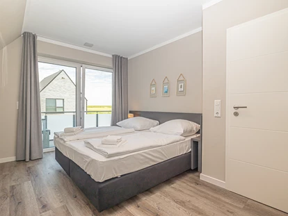 Rollstuhlgerechte Unterkunft - Unterkunftsart: Ferienhaus - Schlafzimmer 3 im Obergeschoss mit 180x200cm Bett und Zugang zum Balkon. Außerdem Kleiderschrank, Kommode und Smart-TV - Korn-Koje