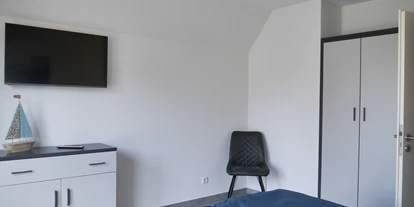 Rollstuhlgerechte Unterkunft - Unterkunftsart: Ferienhaus - Schlafzimmer 2 (OG) mit Kommode, Kleiderschrank und Smart-TV - Ferienbude an den Wehlen
