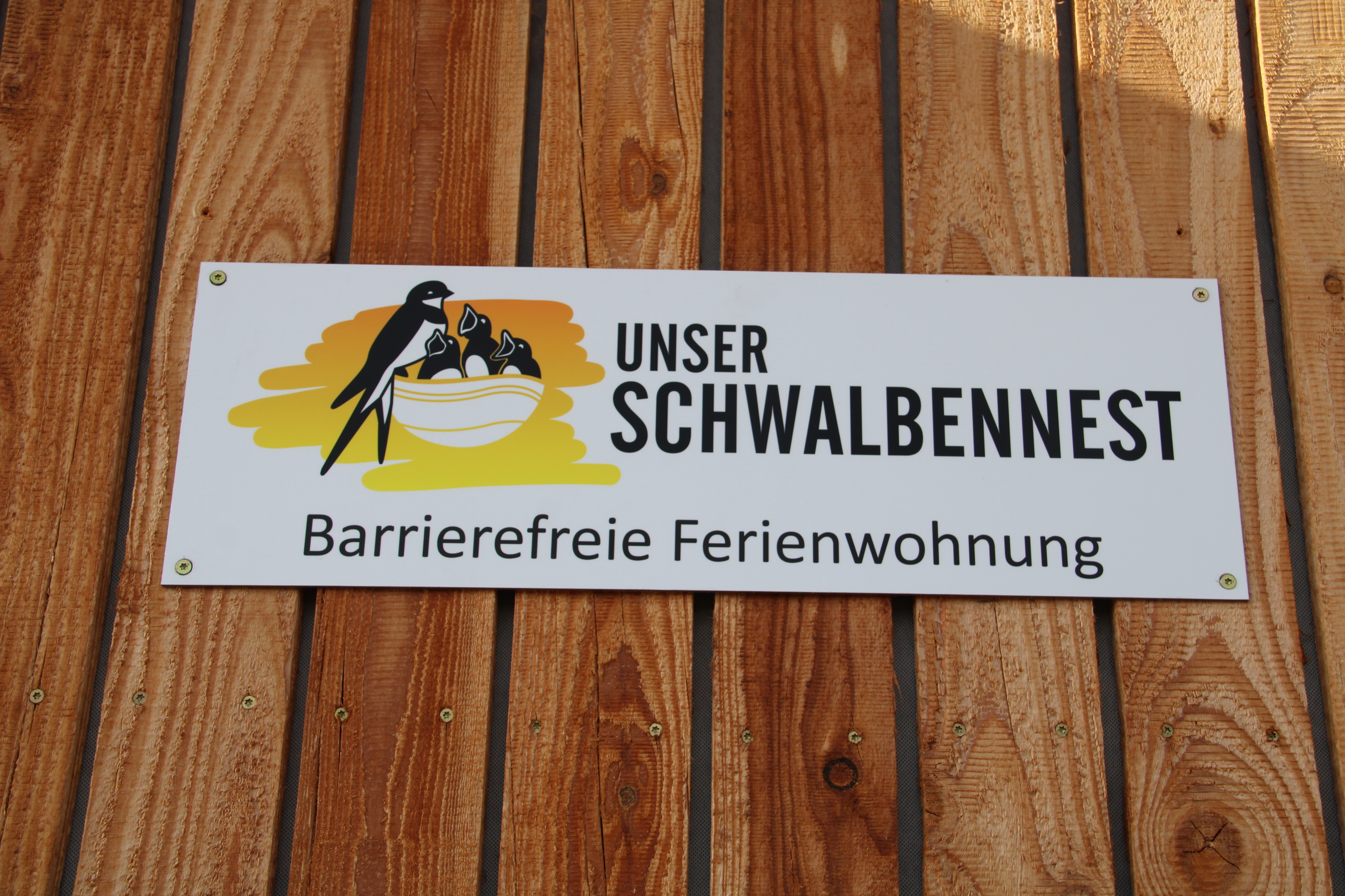 Rollstuhlgerechte Unterkunft - Logo + Hinweisschild "Unser Schwalbennest"  - Unser Schwalbennest
