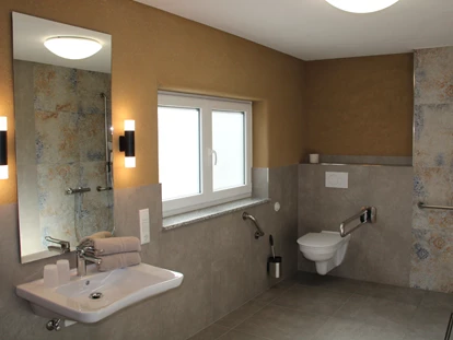 Rollstuhlgerechte Unterkunft - Pflegebett - Waschtisch unterfahrbar, Toilette mit Haltegriffen und zusätzlichen Spülauslöser - Unser Schwalbennest