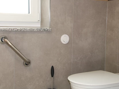 Rollstuhlgerechte Unterkunft - Pflegebett - Stützgriff bei der Toilette, lange Toilette - Unser Schwalbennest