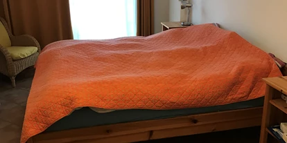 Rollstuhlgerechte Unterkunft - Pflegebett - Kleineres Schlafzimmer mit 1,80 m breitem Ehebett und Zugang auf die Terrasse. - Strand- und hafennahe Ferienwohnung
