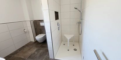 Rollstuhlgerechte Unterkunft - Unterkunftsart: Ferienhaus - Toilette, Dusche mit Duschhocker und Haltegriff - Haus Sonnengruss
