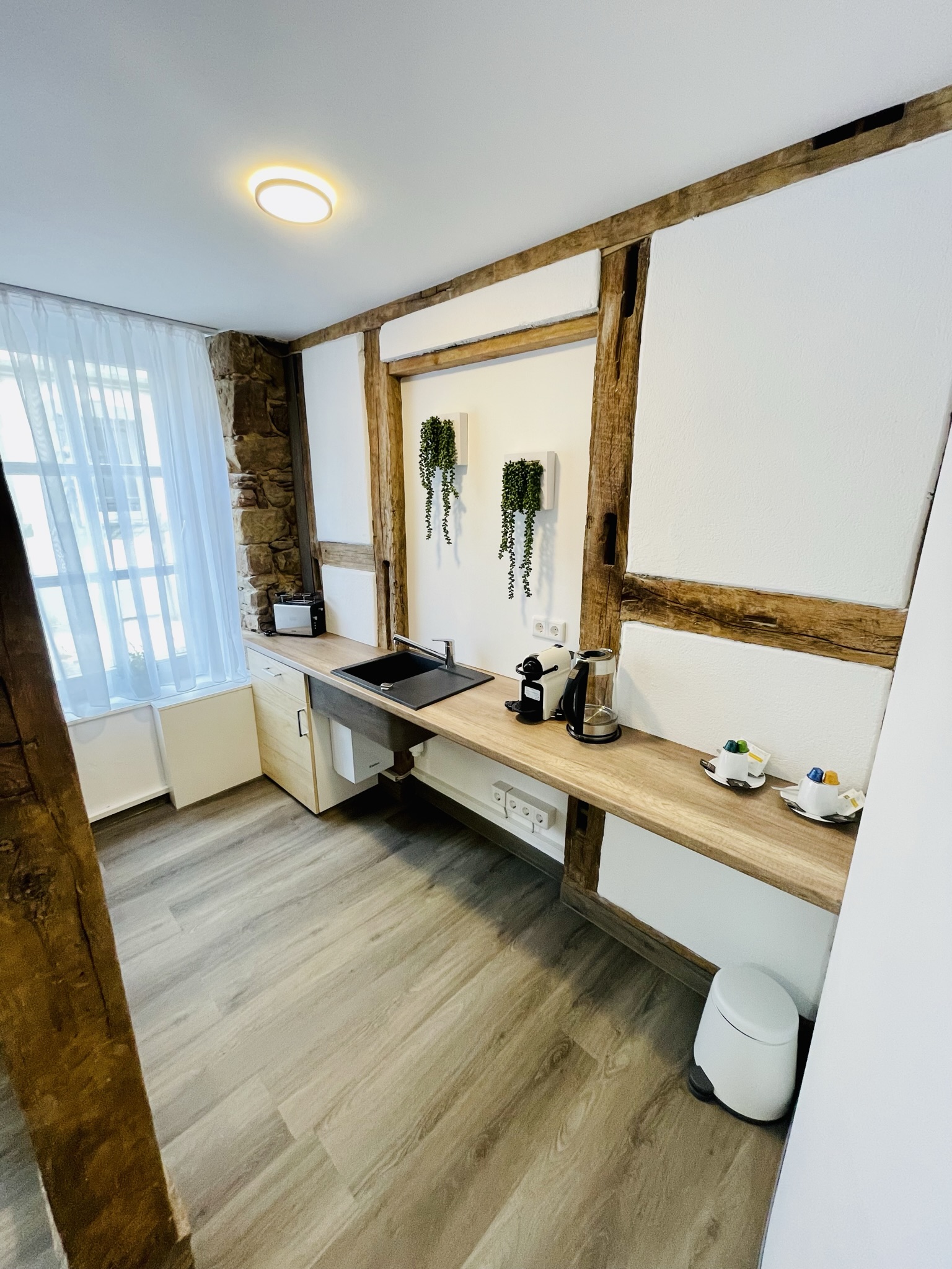 Rollstuhl-Urlaub: kleine unterfahrbare Küchezeile mit Kaffeemaschine, Kühlschrank, Mikrowelle mit Grillfunktion - Hotel am Schloss GmbH & Co. KG