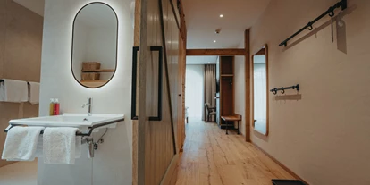 Rollstuhlgerechte Unterkunft - Pflegebett - Das Badezimmer hat eine Schiebetür, das Waschbecken ist unterfahrbar - Biohotel Wildland