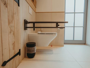 Rollstuhl-Urlaub: neben der Toilette ist ausreichend Platz zum Drehen. Die Toilette besitzt Stützklappgriffe - Biohotel Wildland