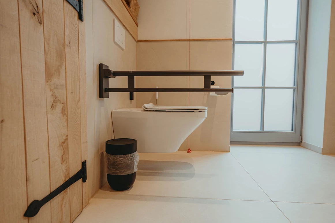 Rollstuhl-Urlaub: neben der Toilette ist ausreichend Platz zum Drehen. Die Toilette besitzt Stützklappgriffe - Biohotel Wildland