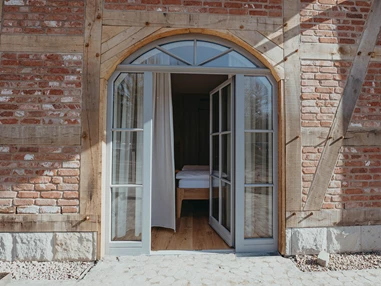 Rollstuhl-Urlaub: An das Zimmer grenzt die Wiese mit einer Terrasse - Biohotel Wildland