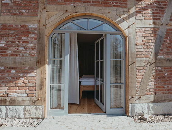 Rollstuhl-Urlaub: An das Zimmer grenzt die Wiese mit einer Terrasse - Biohotel Wildland