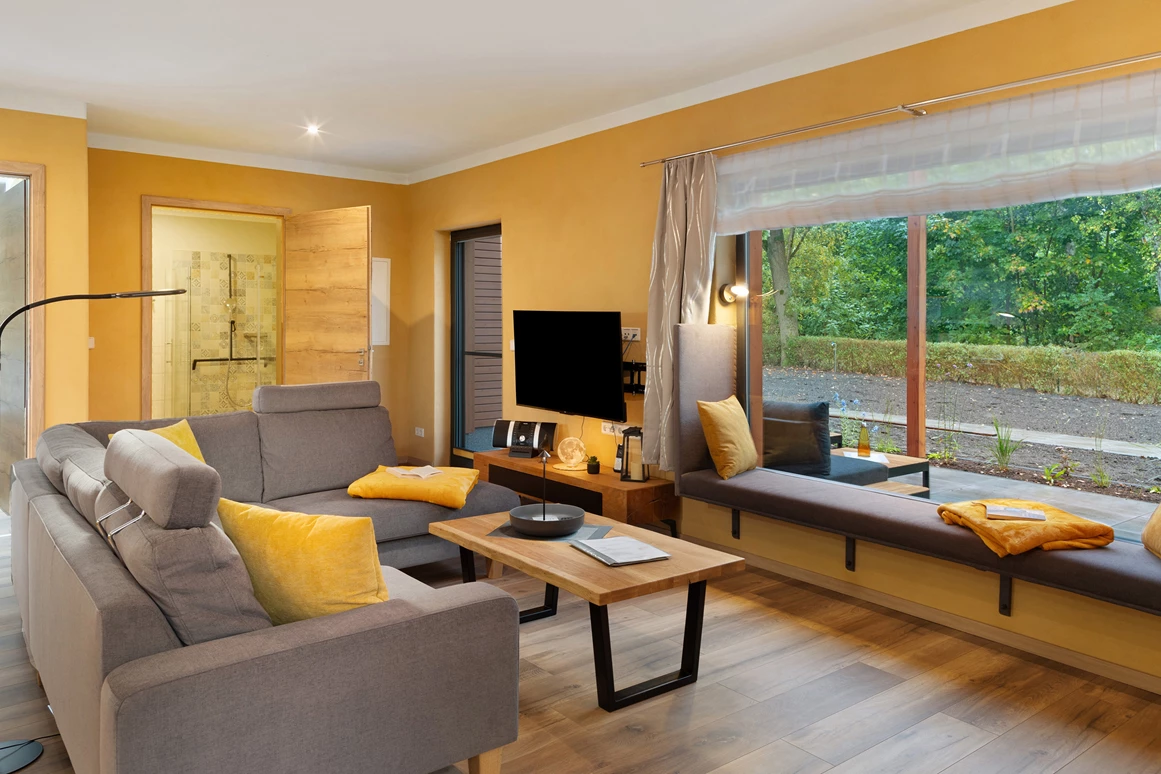 Rollstuhl-Urlaub: Wohnzimmer mit Cougarnitur sowie Panoramafenster.
Im gemütlichen Panoramafenster können  Sie den Blick nach draußen genießen, ein gutes Buch lesen, oder auch schlafen. - Ferienhaus "Milchstraße" im Natur- und Sternenpark Westhavelland