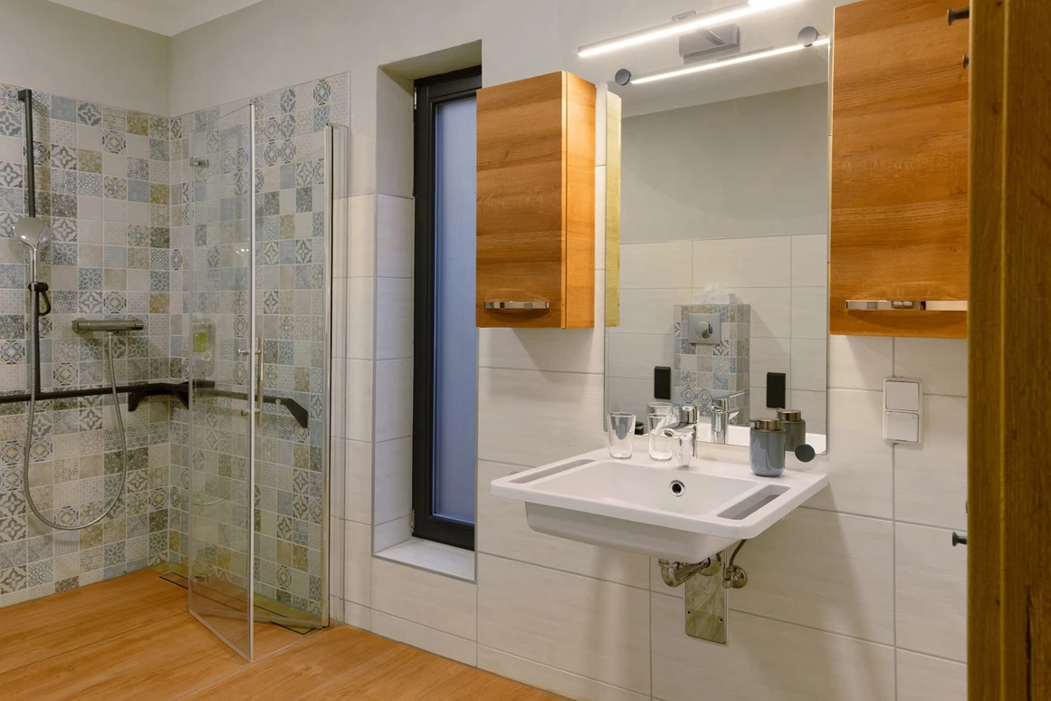 Rollstuhl-Urlaub: Bad mit unterfahrbaren Waschtisch. Optional kann neben den Wandregal und Badschränke, zusätzliche Ablagemöglichkeiten zur Verfügung gestellt werden. - Ferienhaus "Milchstraße" im Natur- und Sternenpark Westhavelland