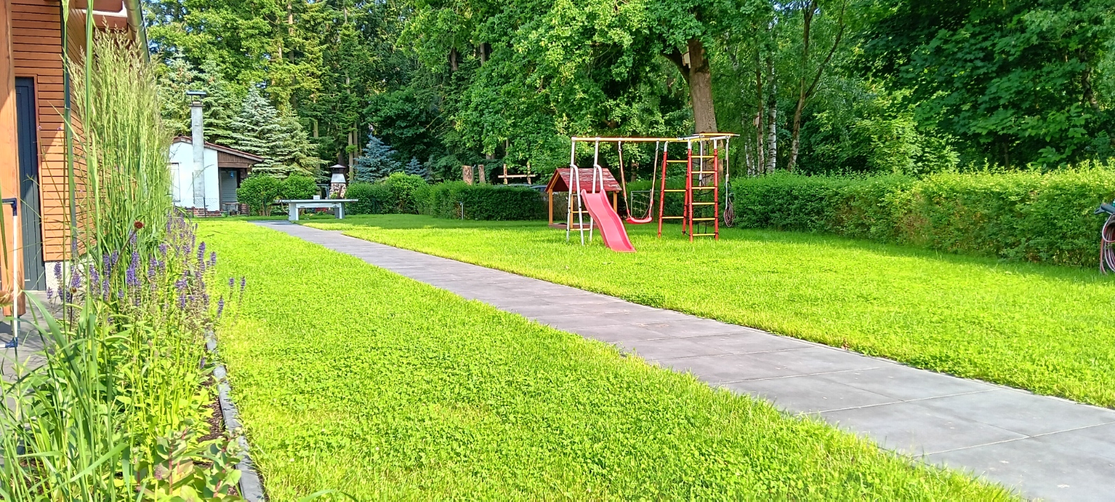 Rollstuhl-Urlaub: Ein Kleinkindspielplatz mit Rutsche, Klettergerüst und Schaukel sowie überdachter Sandkasten, warten auf Ihre Kinder. - Ferienhaus "Milchstraße" im Natur- und Sternenpark Westhavelland