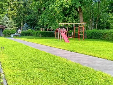 Rollstuhl-Urlaub: Ein Kleinkindspielplatz mit Rutsche, Klettergerüst und Schaukel sowie überdachter Sandkasten, warten auf Ihre Kinder. - Ferienhaus "Milchstraße" im Natur- und Sternenpark Westhavelland