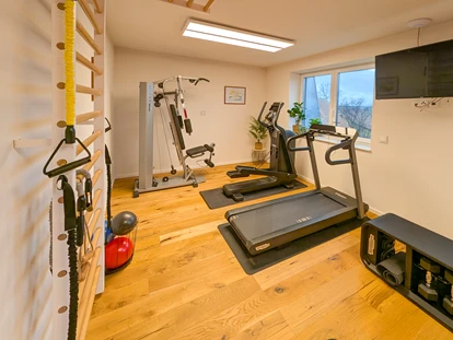 Rollstuhlgerechte Unterkunft - Pflegebett - Aktiv bleiben – Das Fitnesscenter im Gutshof Roggow
Das hauseigene Fitnesscenter steht allen Gästen und Bewohnern kostenfrei zur Verfügung und bietet hochwertige Geräte für ein umfassendes Training: Crosstrainer, Bike und Kraftstation von Technogym, die bewährte Rudermaschine von Concept2 sowie Sprossenwand und Freihanteln. Abgerundet wird das Angebot durch einen Massagesessel – ideal zur Entspannung nach dem Training. Große Fenster sorgen für einen hellen, freundlichen Raum mit Blick ins Grüne. - Gutshof Roggow bei Güstrow
