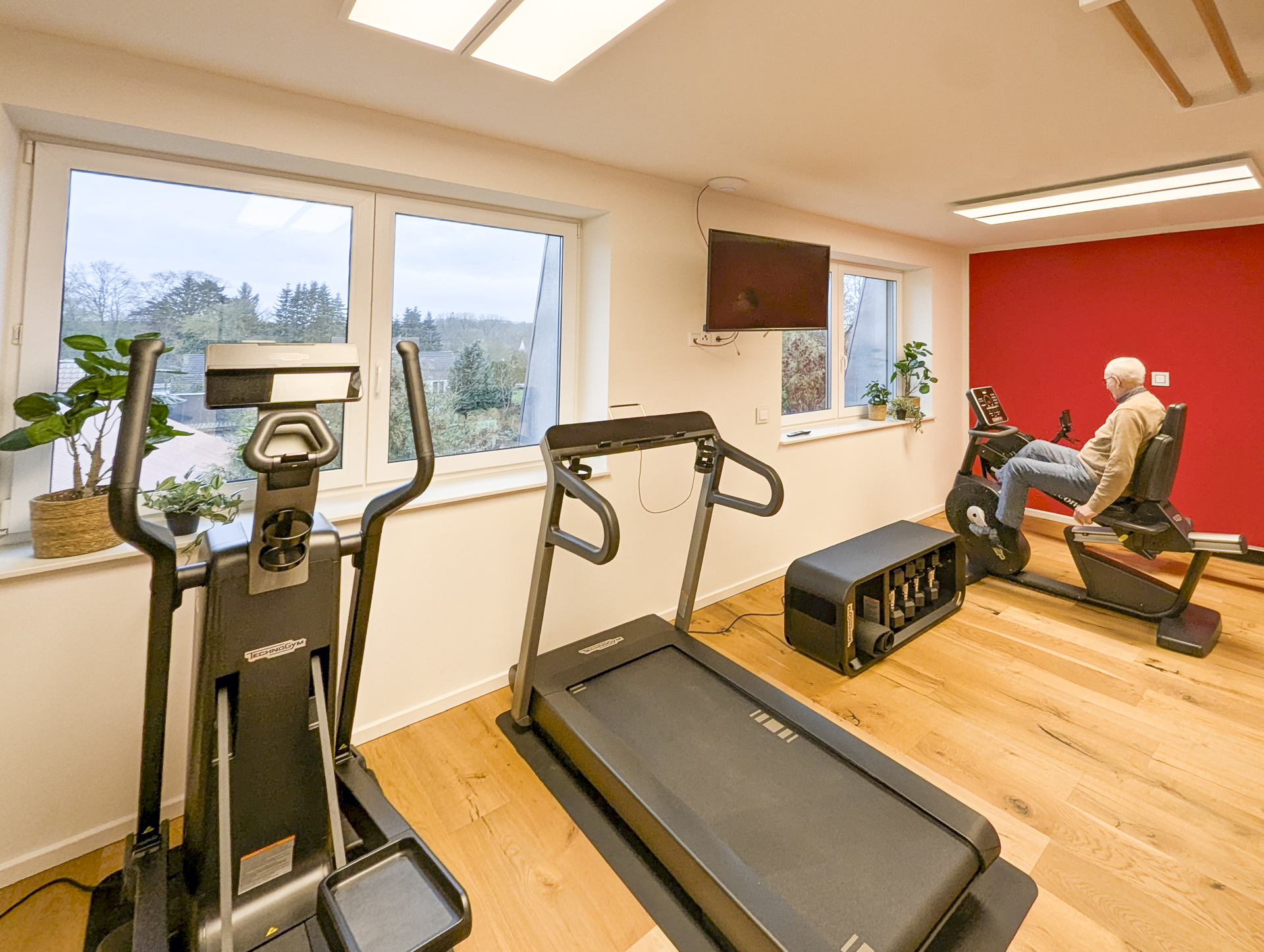 Rollstuhl-Urlaub: Aktiv bleiben – Das Fitnesscenter im Gutshof Roggow

Das hauseigene Fitnesscenter steht allen Gästen und Bewohnern kostenfrei zur Verfügung und bietet hochwertige Geräte für ein umfassendes Training: Crosstrainer, Bike und Kraftstation von Technogym, die bewährte Rudermaschine von Concept2 sowie Sprossenwand und Freihanteln. Abgerundet wird das Angebot durch einen Massagesessel – ideal zur Entspannung nach dem Training. Große Fenster sorgen für einen hellen, freundlichen Raum mit Blick ins Grüne. - Gutshof Roggow bei Güstrow