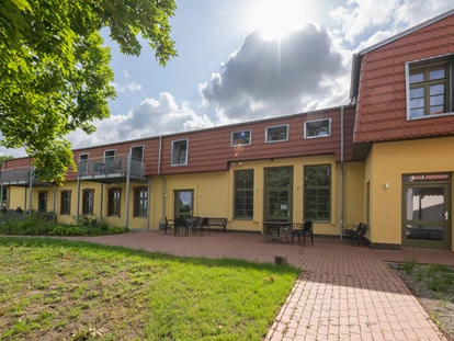 Rollstuhlgerechte Unterkunft - Pflegebett - Ein Park zum Verweilen – Die grüne Oase des Gutshofes Roggow
Rund um den Gutshof Roggow erstreckt sich eine liebevoll gestaltete Parkanlage, die mit ihrem alten Baumbestand und weitläufigen Wiesen zum Innehalten einlädt. Das Gewächshaus mit gemütlicher Sitzecke für kühlere Tage, eine idyllische Schafweide, ein kleiner Teich und die artenreiche Streuobstwiese sowie die professionell angelegten Staudenbeete verleihen dem Park seinen besonderen Charakter. Gepflegte Wege führen vorbei an sonnigen und schattigen Plätzen, während zahlreiche Sitzbänke Gelegenheit bieten, den Blick über die mecklenburgische Landschaft schweifen zu lassen.
Ein Ort, der Ruhe schenkt und zugleich Raum für Begegnung und Naturerlebnis bietet – für unsere Feriengäste ebenso wie für Besucher des Gutshofes. - Gutshof Roggow bei Güstrow