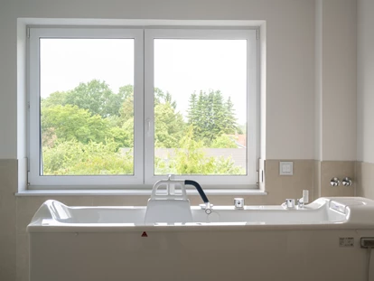 Rollstuhlgerechte Unterkunft - Pflegebett - Komfort ohne Barrieren – Rollstuhlgerechte Bäder im Gutshof Roggow
Neben den barrierefreien Bädern in den Gästezimmern verfügen beide Häuser des Gutshofes über großzügige, nach höchsten Standards eingerichtete rollstuhlgerechte Bäder. Sie sind mit bodengleichen Duschen, Haltegriffen, unterfahrbaren Waschbecken sowie modernster Ausstattung versehen und bieten damit optimale Bedingungen für Gäste mit besonderen Mobilitätsbedürfnissen. - Gutshof Roggow bei Güstrow