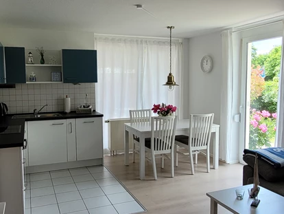Rollstuhlgerechte Unterkunft - Küche, Esstisch, Ausgang Terrasse ( Absatz 2,5 cm) . Ganz rechts steht das Sofa - FeWo Seewind barrierefrei Überlingen am Bodensee