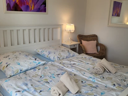 Rollstuhlgerechte Unterkunft - Bett. Es gibt einen doppelten großen Kleiderschrank mit Schiebetüren (in weiß), mit Kleiderbügel. Der Schrank ist für allein reisende Rollstuhlfahrer schlecht zu bedienen. Ihr könnt dafür den Schrank im Flur nutzen. Bitte vor Anreise bescheid geben. - FeWo Seewind barrierefrei Überlingen am Bodensee
