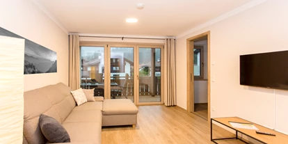 Rollstuhlgerechte Unterkunft - Oberbayern - Wohnzimmer Richtung Balkon & Eingang Küche - Ferienwohnungen Alpenflair - barrierefrei urlauben
